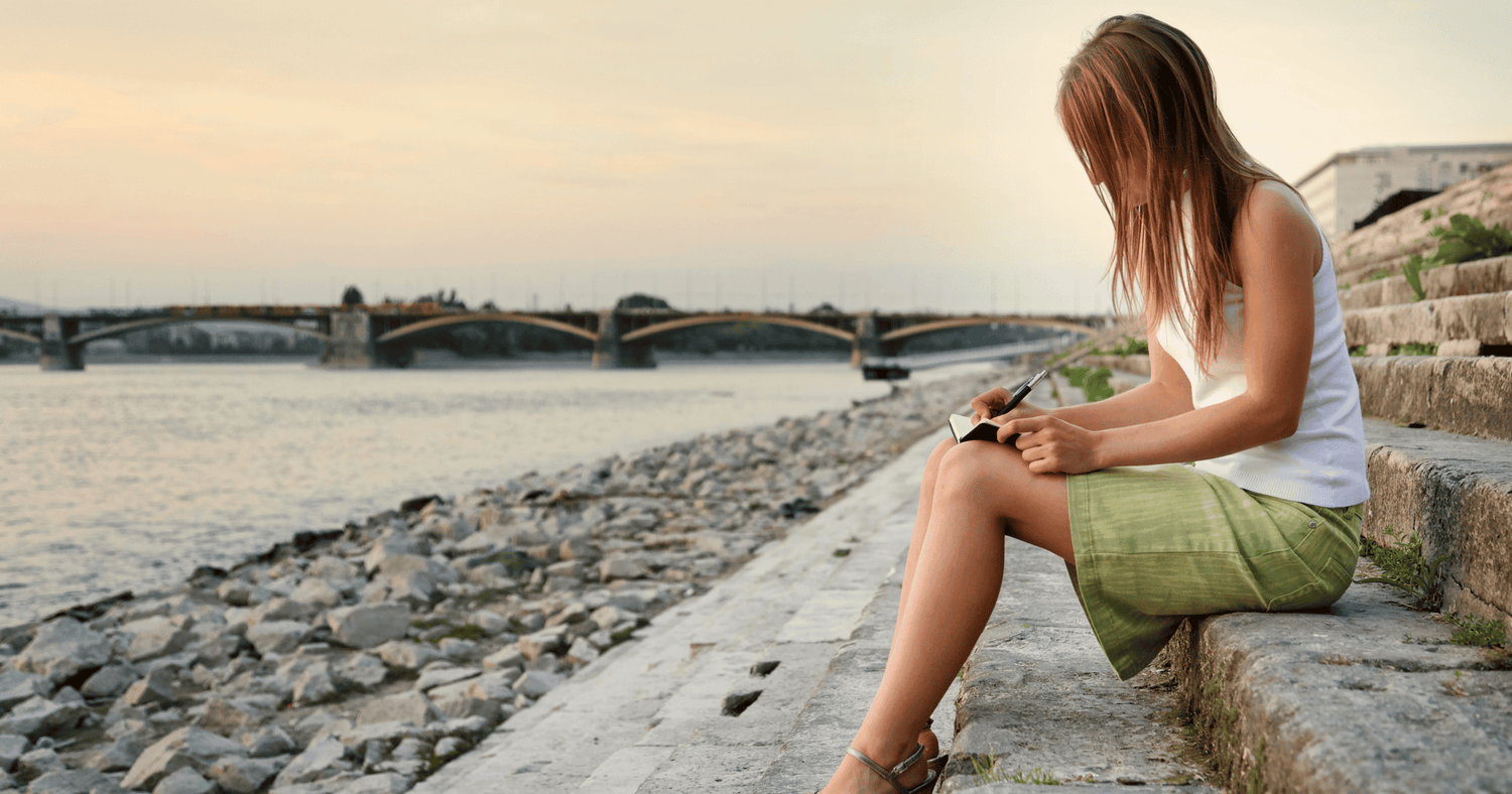 Woman journaling by the beach